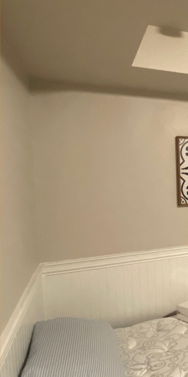 The bedroom finished with white beadboard wainscoting